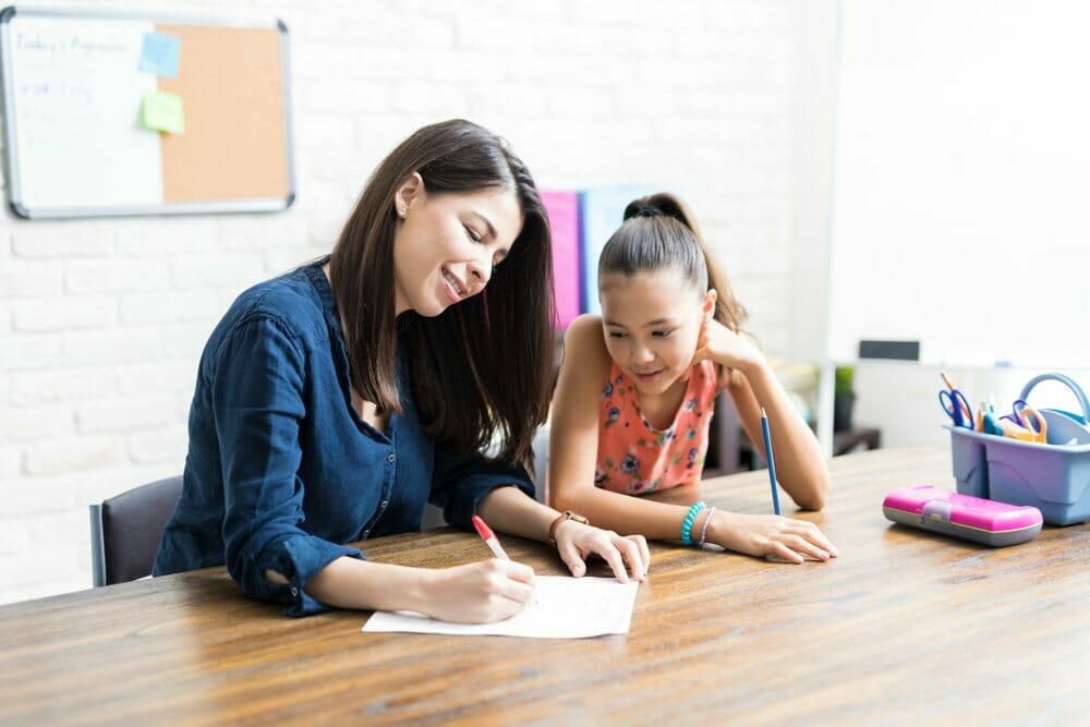 Madre ayuda a su hija con los deberes escolares.