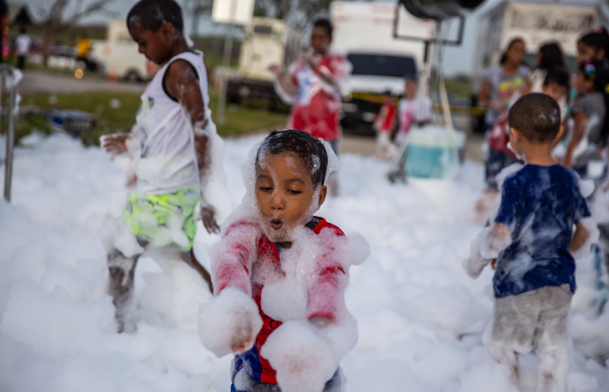 Niños participan en una fiesta de espuma.