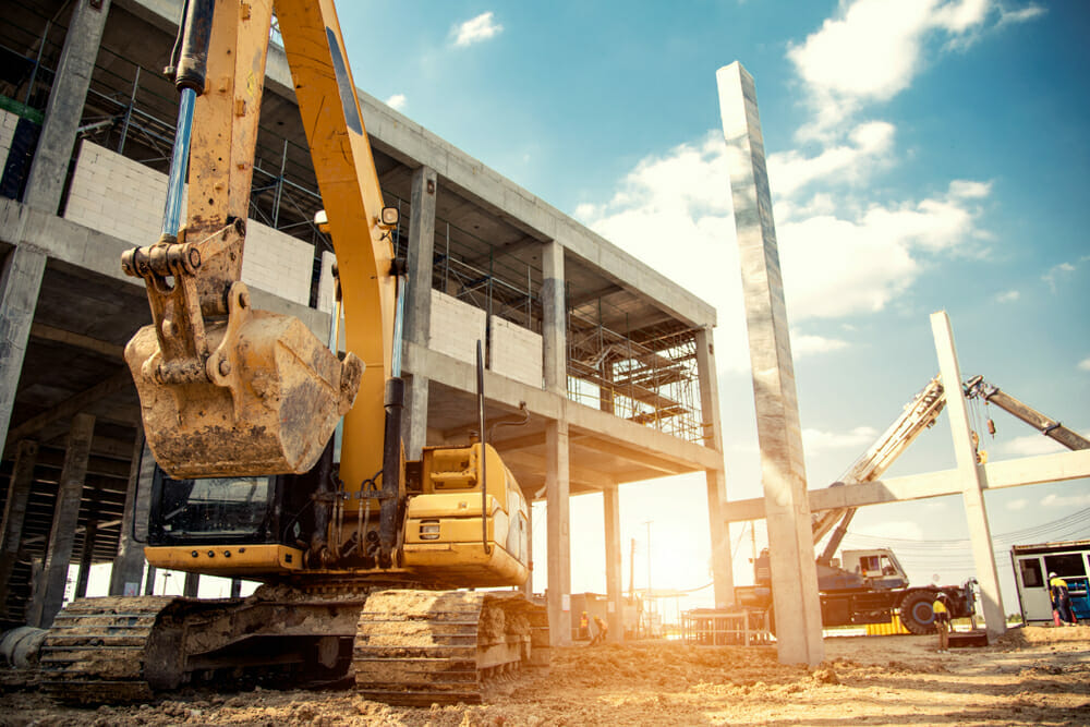Obras de construcción en Panamá Oeste. Dos excavadoras y un edificio en construcción.