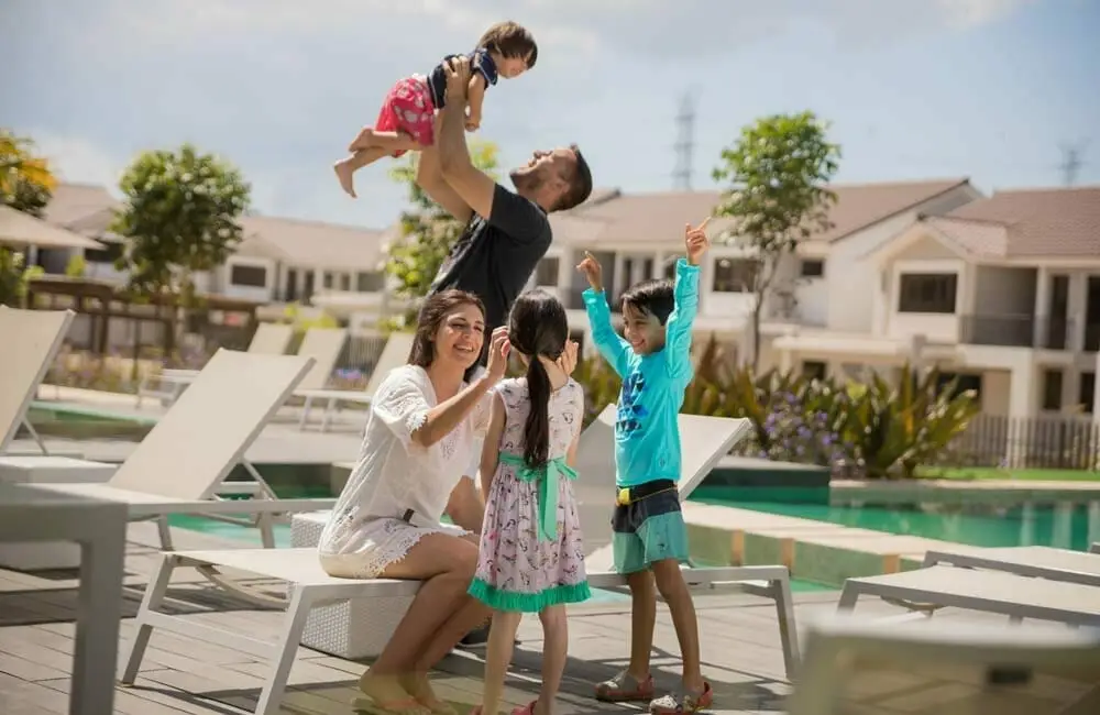 Madre, padre, hija y 2 hijos relajándose cerca de la piscina en Paseo del Norte.