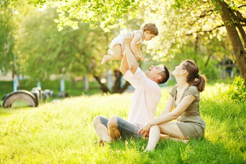 Madre, padre e hija pasan el tiempo en un entorno natural.