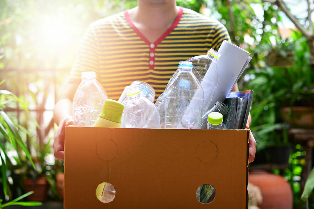Hombre con una caja llena de botellas de plástico participa en el Reciclotón en Paseo del Norte.