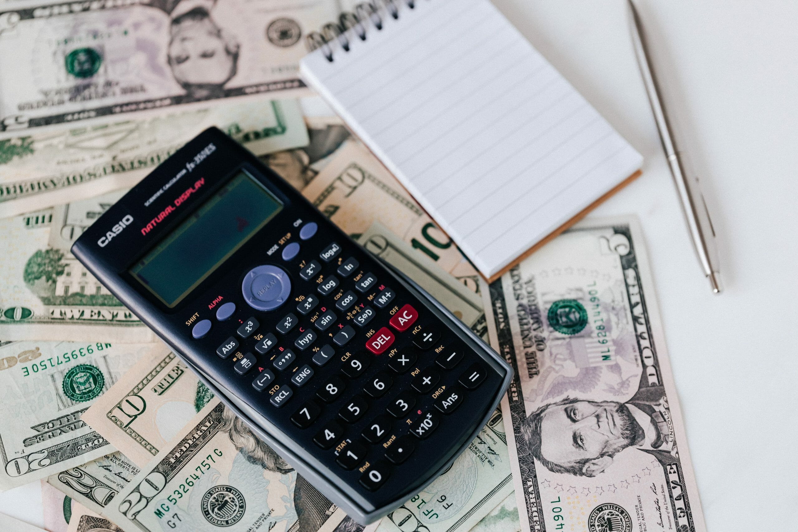 Una calculadora con dinero y una libreta vacia