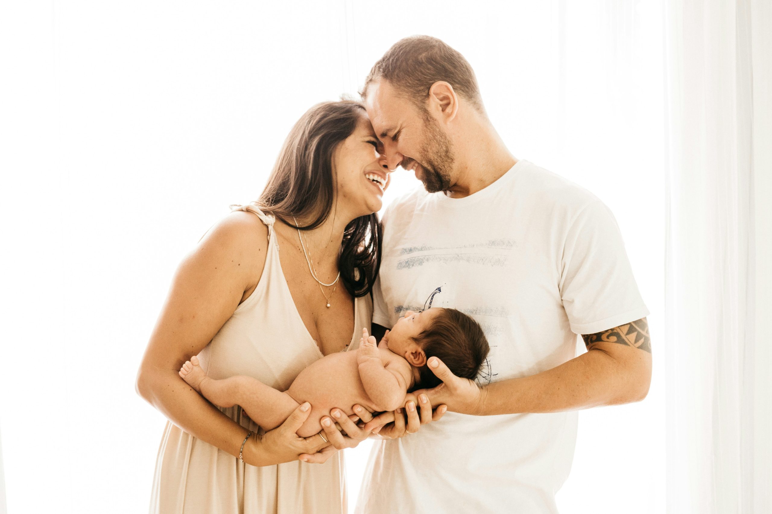 Padre y madre cargando a su bebé recién nacido en su nuevo hogar.