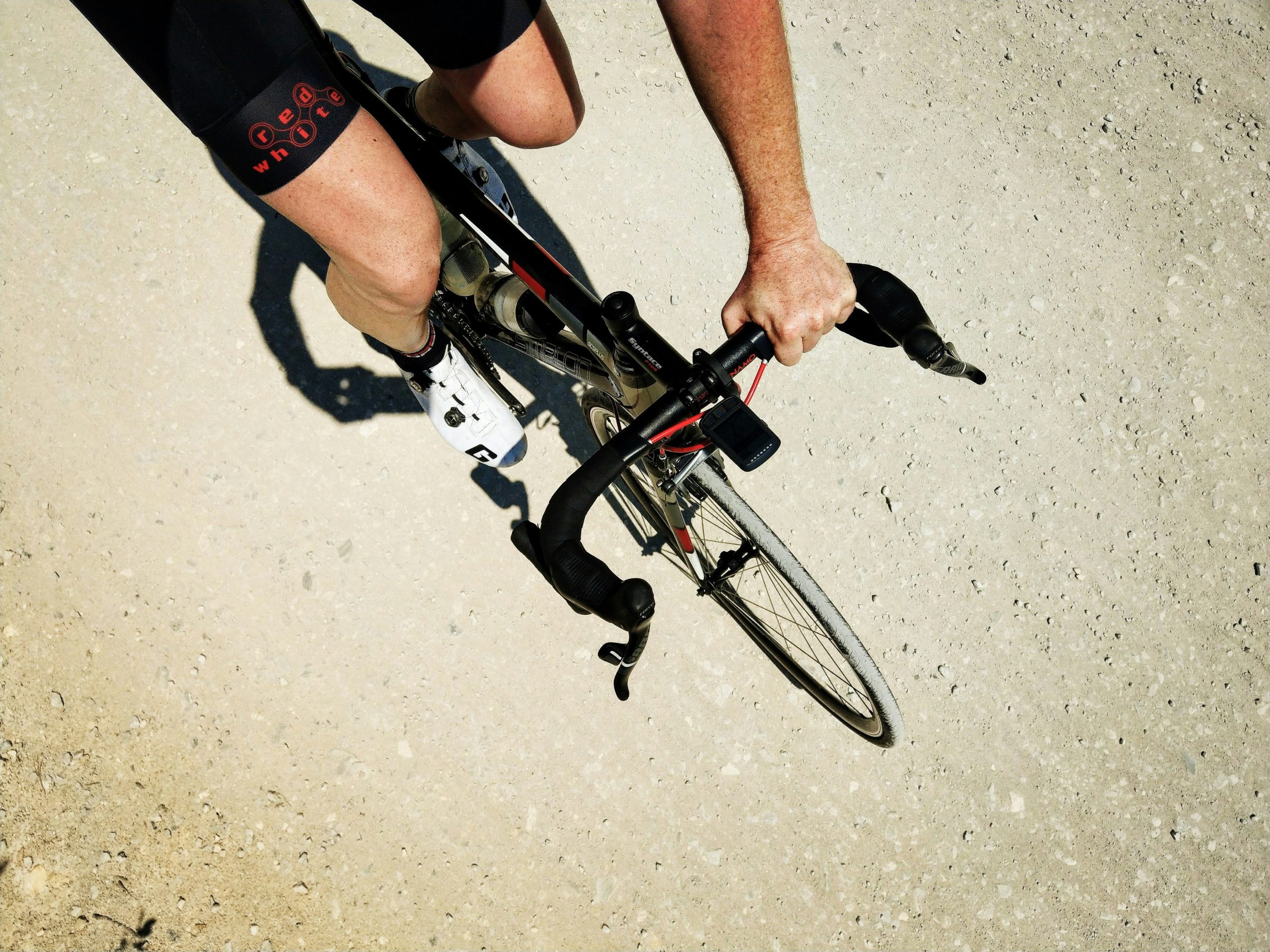 Ciclista sujetándose al timón de su bicicleta con una mano.