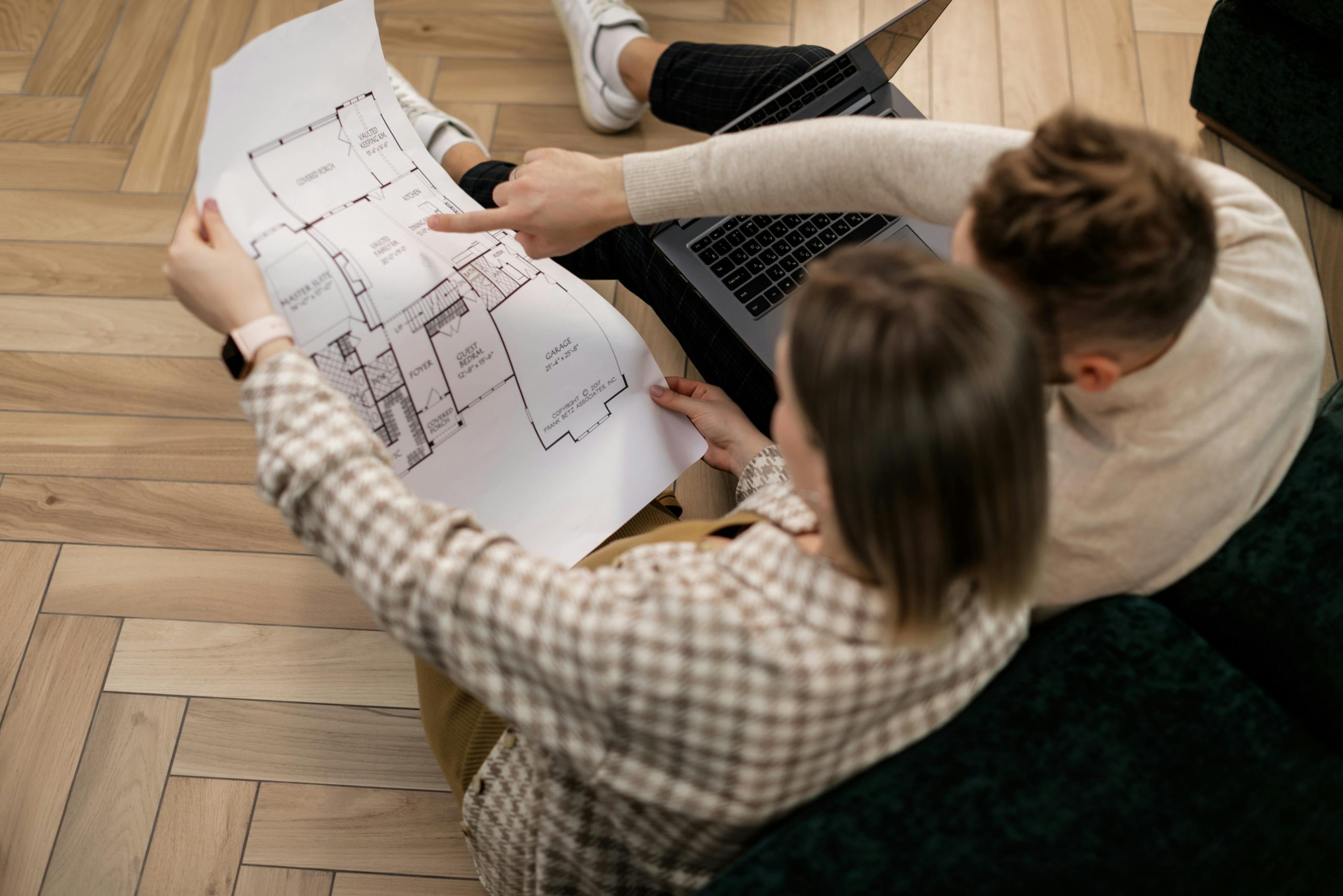 Pareja revisando planos arquitectónicos con la distribución de su casa nueva en Panamá.