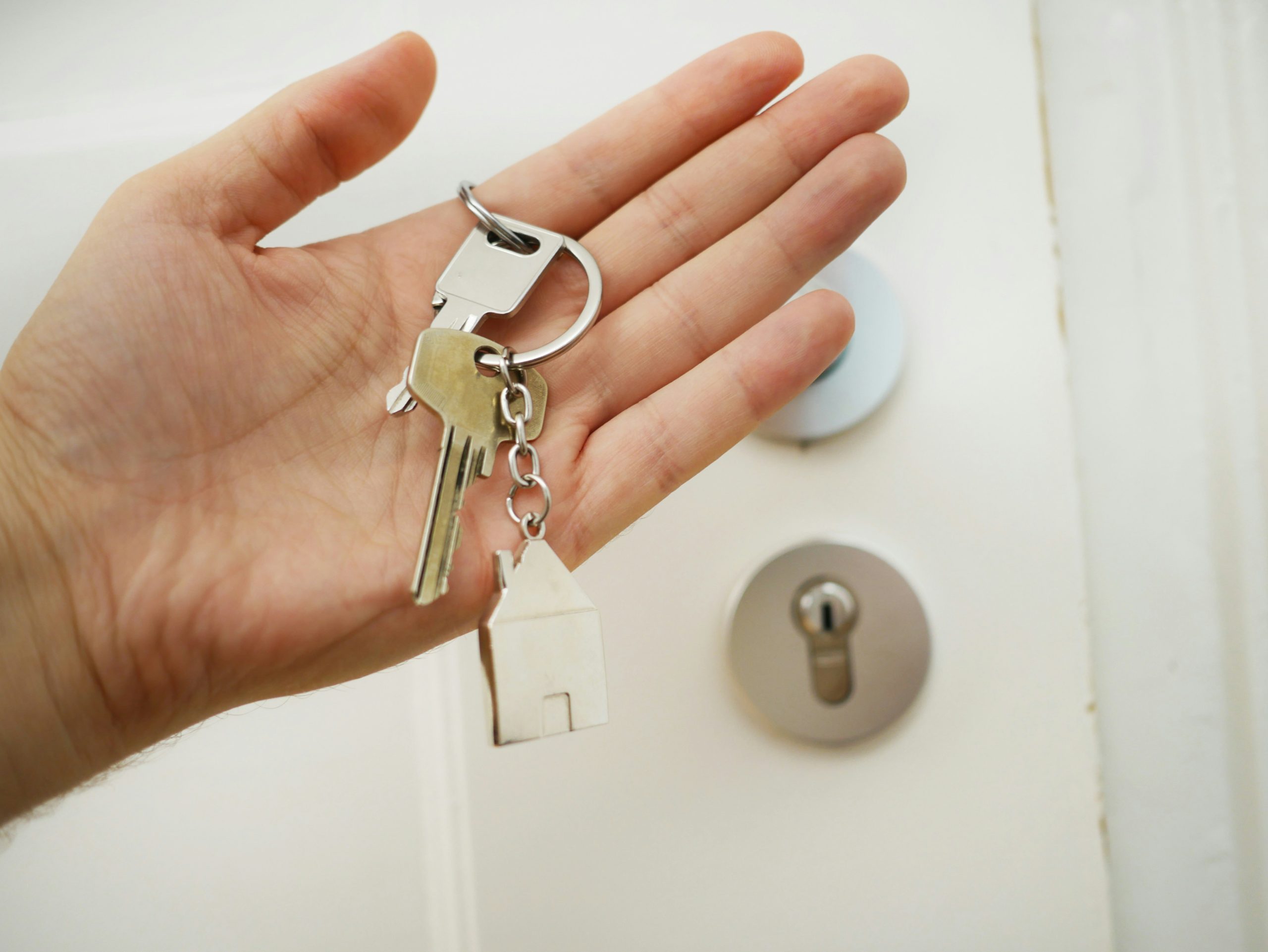 Mano sosteniendo llaves de primera vivienda.