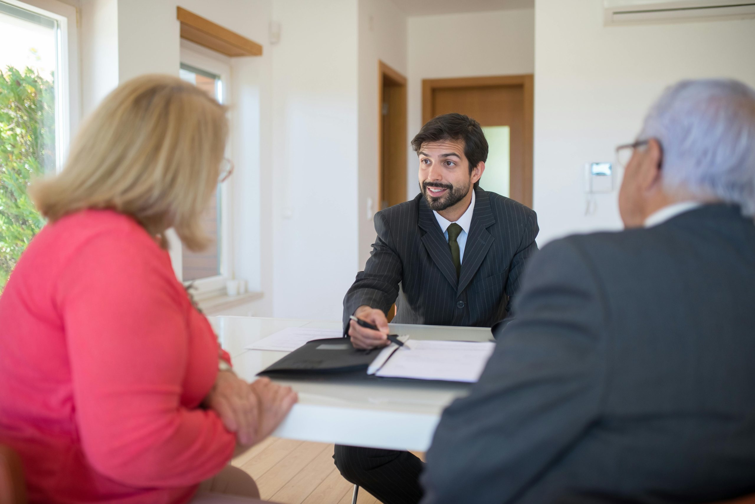 Agente de bienes raíces mostrando opciones financieras a clientes.