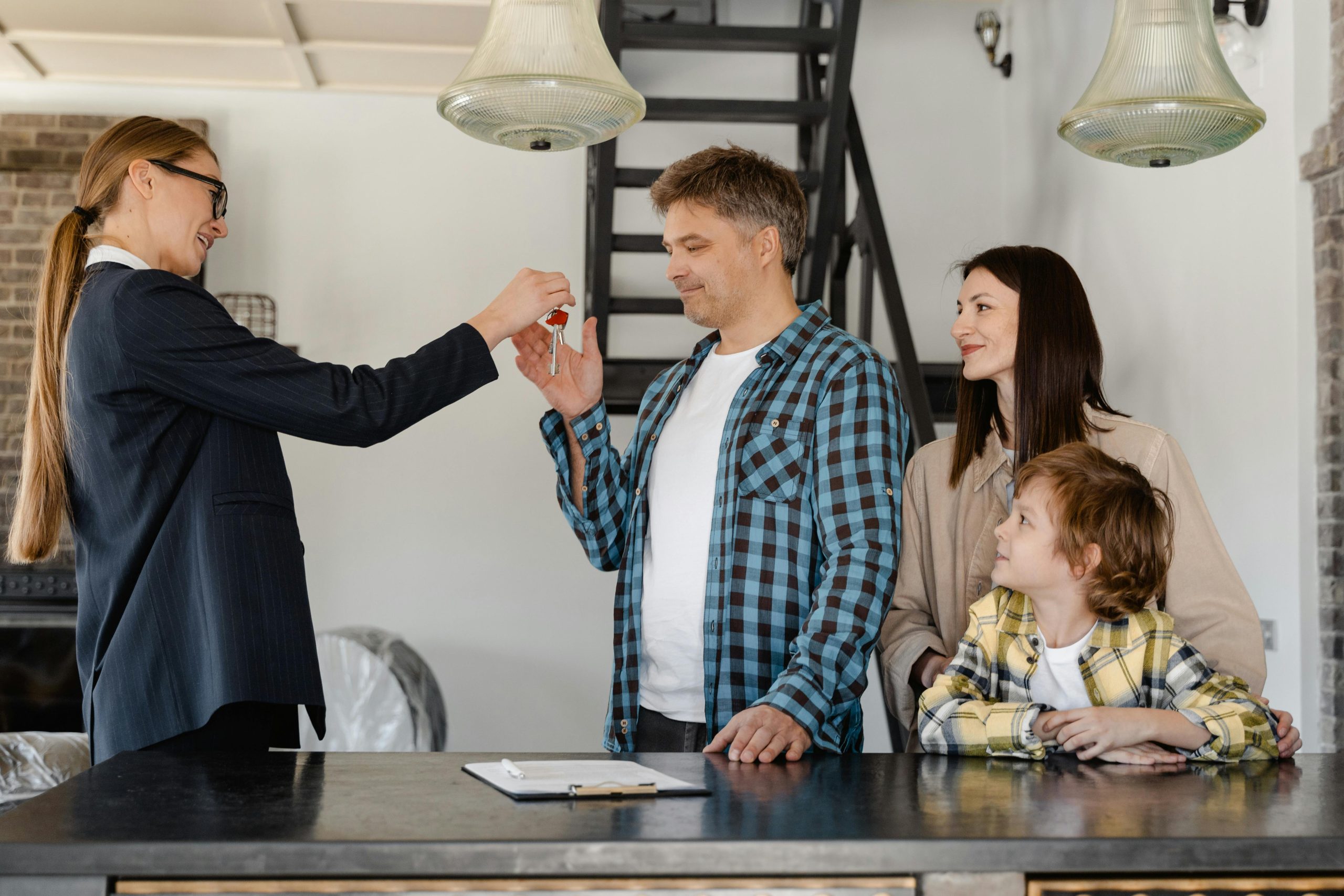 Una agente inmobiliaria entregando la llave a nuevos propietarios de vivienda