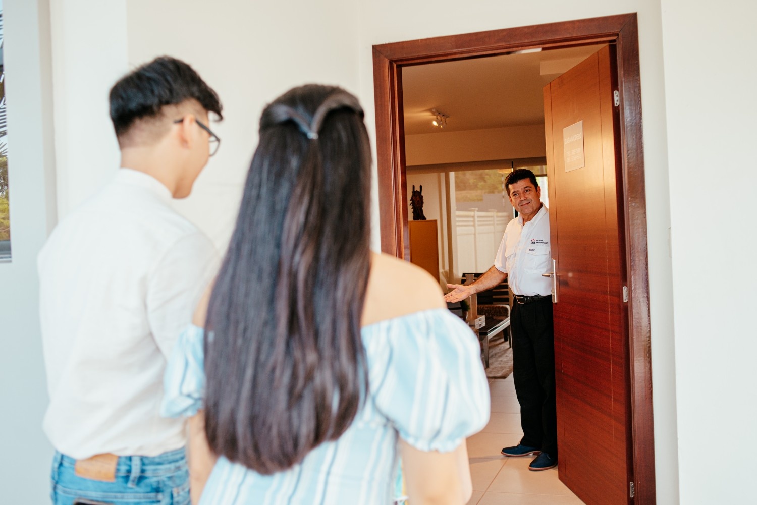 Agente inmobiliario de Grupo Residencial mostrando una vivienda en proyecto de casas a dos personas.