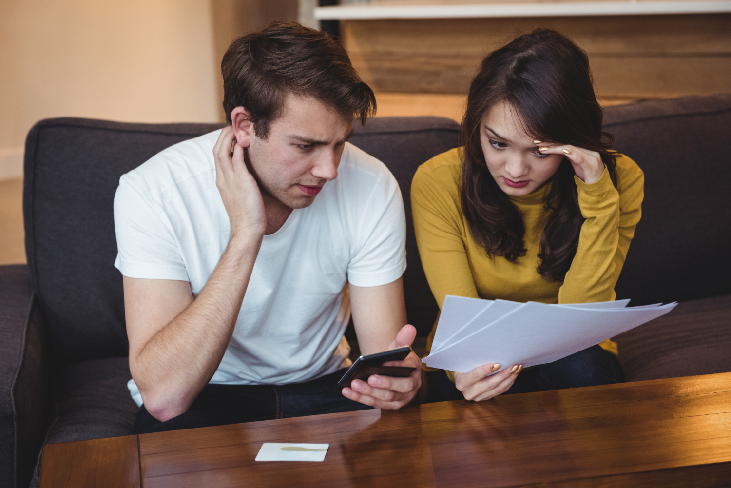 Pareja preocupada revisando documentos de hipoteca 